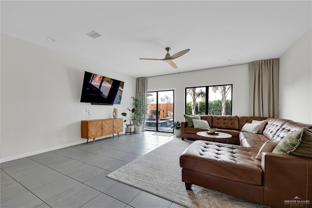 tiled living room featuring baseboards, a ceiling fan, and visible vents