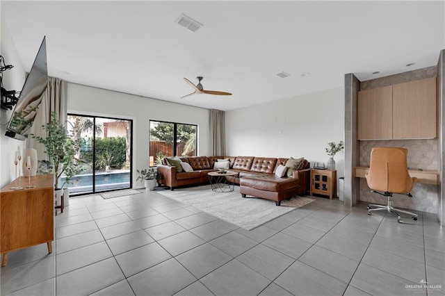 living room featuring ceiling fan, visible vents, and light tile patterned floors