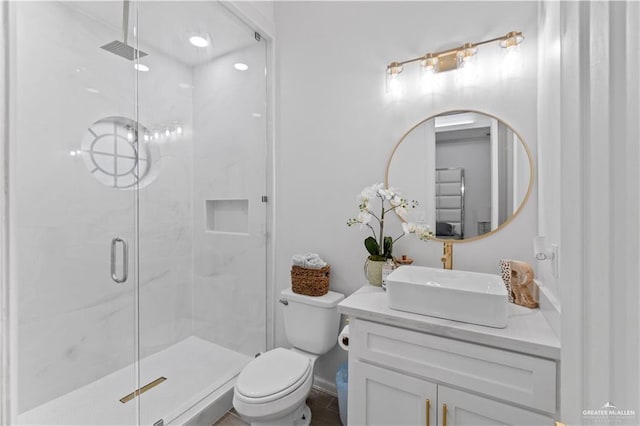 bathroom featuring vanity, toilet, and a shower with shower door