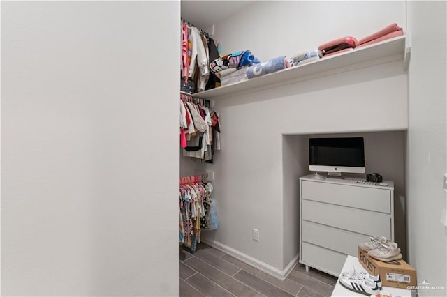 spacious closet with dark hardwood / wood-style flooring