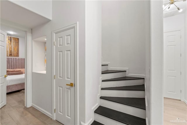 stairs featuring a chandelier and hardwood / wood-style floors