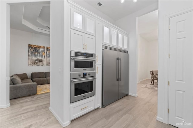 kitchen with white cabinetry, ceiling fan, light hardwood / wood-style floors, and appliances with stainless steel finishes