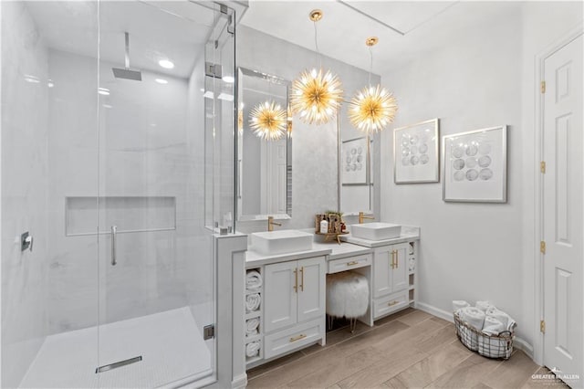 bathroom featuring wood-type flooring, vanity, and a shower with shower door