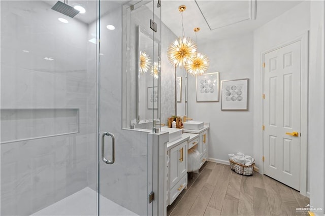 bathroom with hardwood / wood-style flooring, vanity, and an enclosed shower