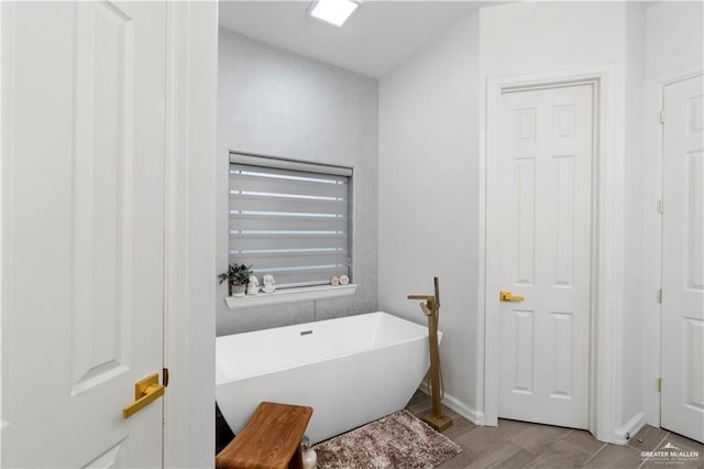 bathroom with a bathtub and wood-type flooring