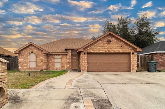 ranch-style house featuring driveway, an attached garage, roof with shingles, and brick siding