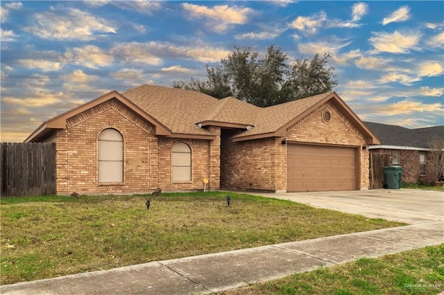 ranch-style home with concrete driveway, brick siding, a lawn, and an attached garage