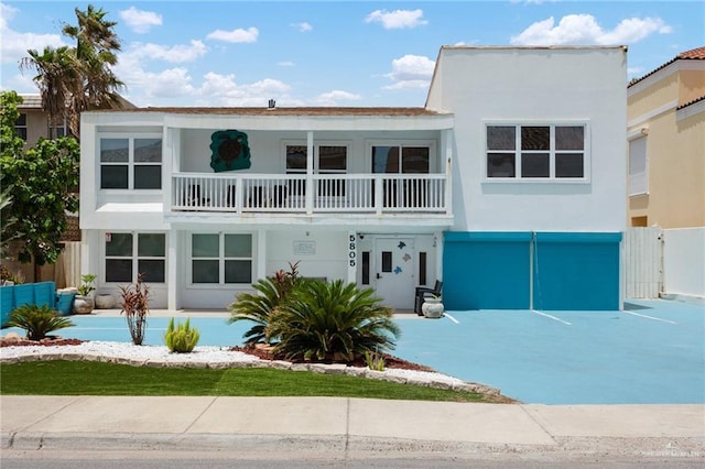 5805 Gulf Blvd, South Padre Island, TX 78597 - view of front facade with a balcony, stucco siding, a porch, and an attached garage