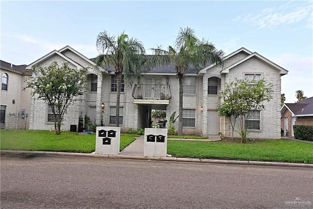 view of front of property with a balcony and a front yard