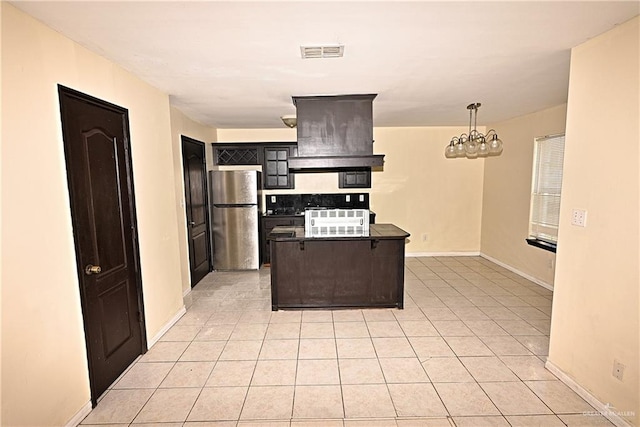 kitchen with stainless steel fridge, premium range hood, light tile patterned floors, and pendant lighting