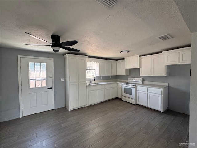 kitchen with a sink, dark wood finished floors, white electric range, visible vents, and white cabinets