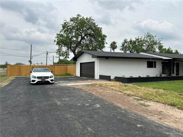 147 W Austin Blvd, Edinburg, TX 78539 - view of side of property with fence, driveway, and a garage
