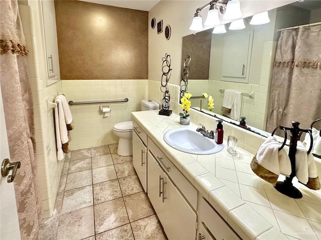 bathroom featuring vanity, tile walls, and toilet