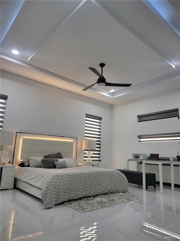 bedroom with ceiling fan and a raised ceiling