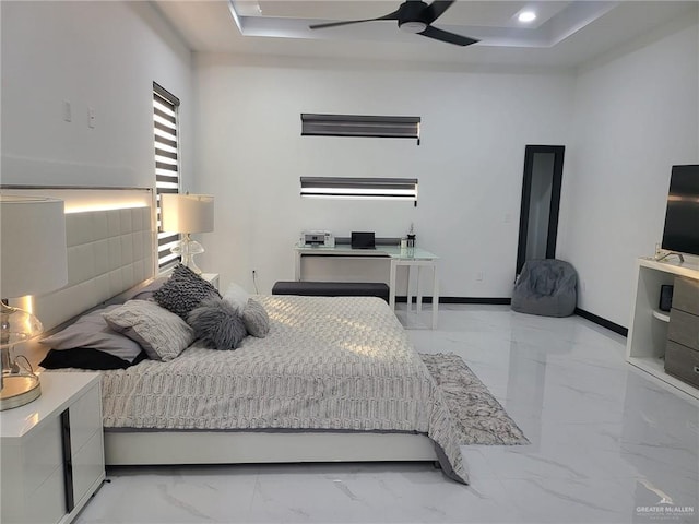 bedroom with ceiling fan and a tray ceiling