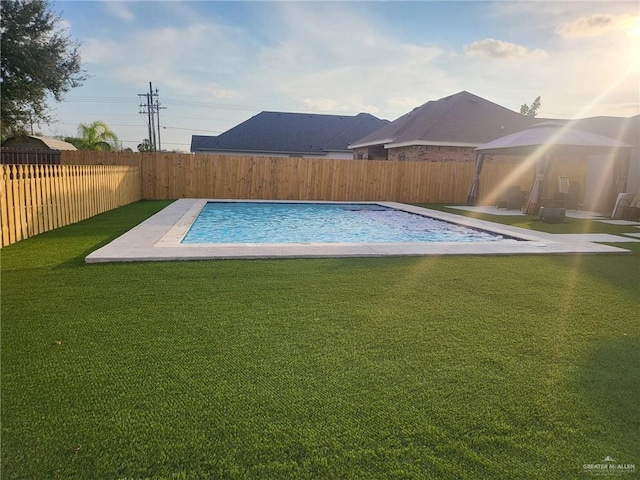 view of swimming pool with a yard