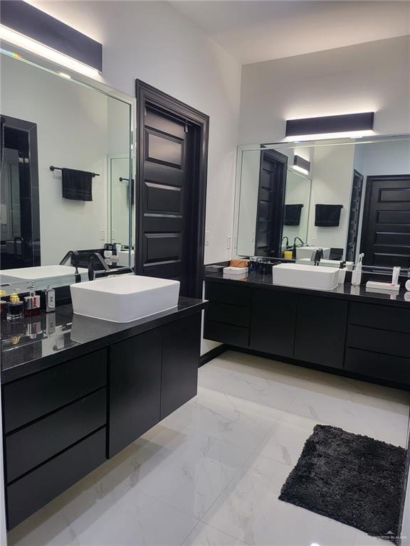 bathroom with a shower with door and vanity