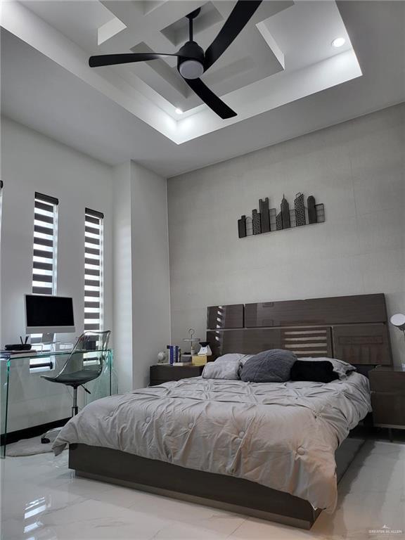 bedroom with a raised ceiling and ceiling fan