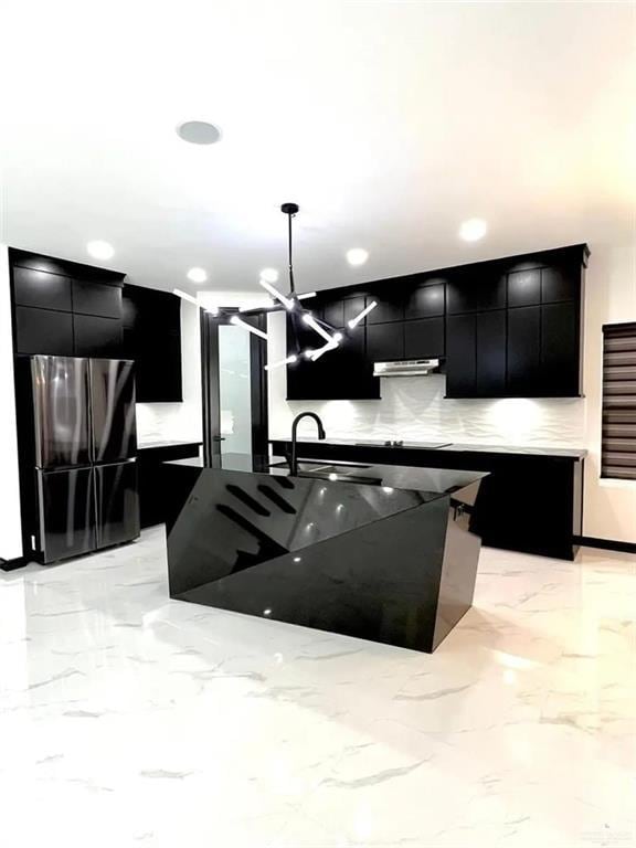 kitchen with a kitchen island with sink, sink, decorative light fixtures, and decorative backsplash