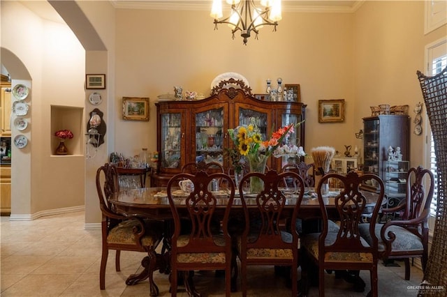 dining space with arched walkways, light tile patterned floors, a notable chandelier, crown molding, and a towering ceiling