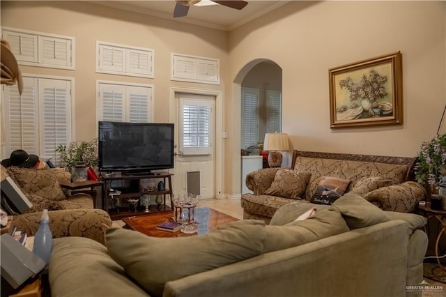 living room with arched walkways, ceiling fan, and crown molding