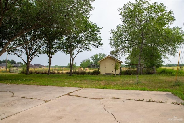 view of yard featuring a rural view, a patio area, and a storage shed