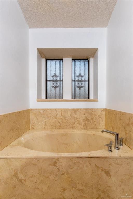 bathroom featuring a textured ceiling and a bathtub