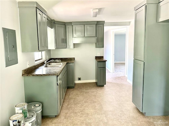 kitchen with sink, electric panel, and dark stone counters