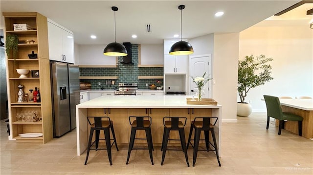2800 Encke Rd, Mission, TX 78574 - kitchen with appliances with stainless steel finishes, wall chimney range hood, white cabinetry, tasteful backsplash, and light countertops