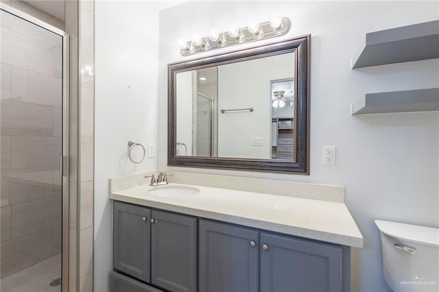 bathroom with toilet, walk in shower, and vanity