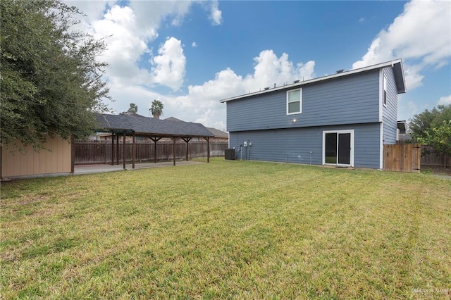 back of house with central AC and a yard