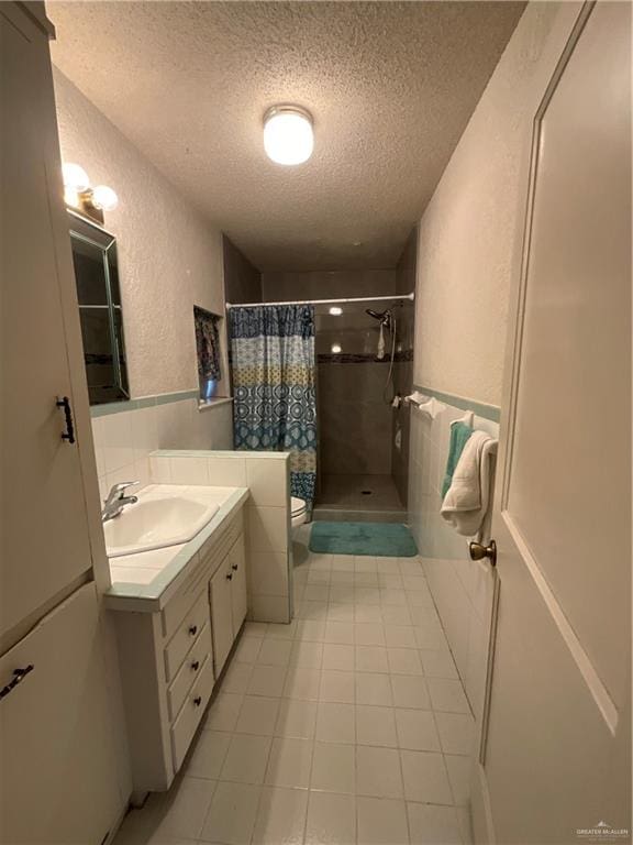 bathroom with tile patterned flooring, a textured ceiling, toilet, vanity, and a shower with shower curtain