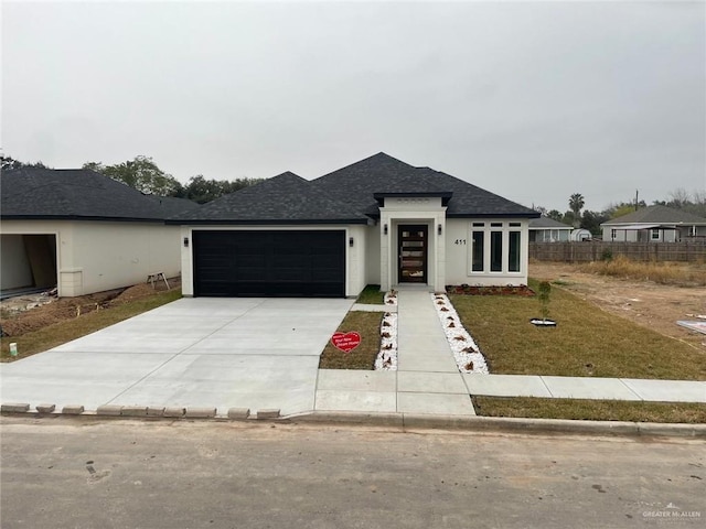 view of front of house featuring a garage and a front lawn