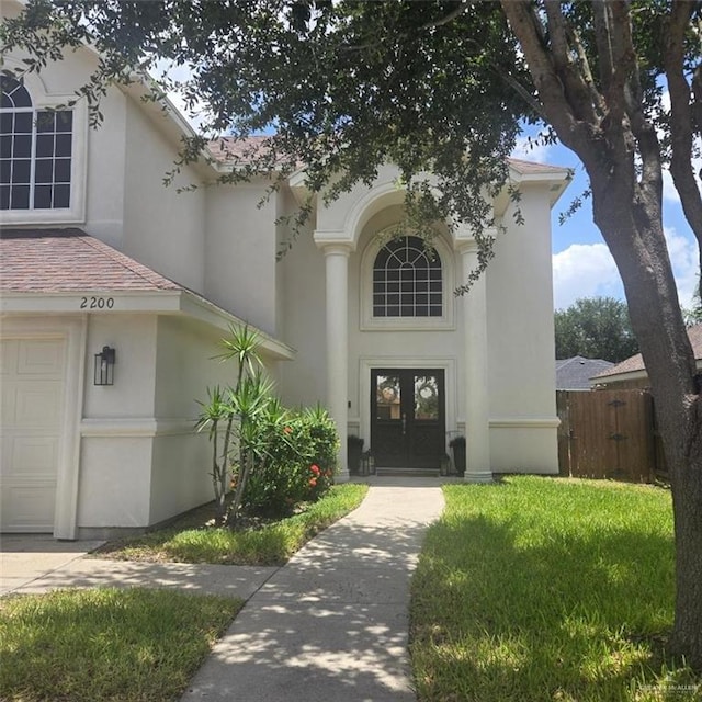 2200 N H St, Mcallen, TX 78501 - doorway to property featuring stucco siding, french doors, and a garage