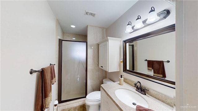 full bathroom featuring toilet, a stall shower, visible vents, and vanity