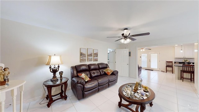 living room with a ceiling fan, baseboards, french doors, and light tile patterned flooring