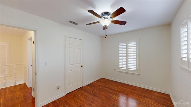 unfurnished bedroom featuring a ceiling fan, wood finished floors, visible vents, and baseboards