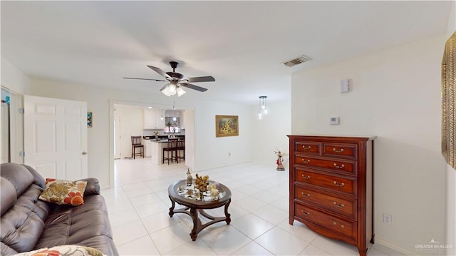 living area with light tile patterned floors, ceiling fan, and visible vents