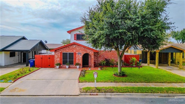 view of front of home with brick siding, a front yard, and fence