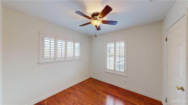 spare room featuring wood finished floors, a ceiling fan, and baseboards