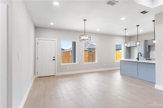 3925 S Mullin Ave, Edinburg, TX 78542 - kitchen with light wood finished floors, light countertops, recessed lighting, a chandelier, and decorative light fixtures