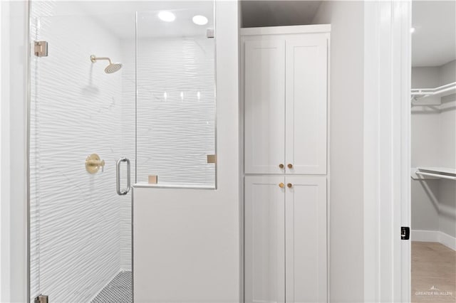 3925 S Mullin Ave, Edinburg, TX 78542 - full bathroom featuring a shower stall, wood finished floors, a walk in closet, and recessed lighting