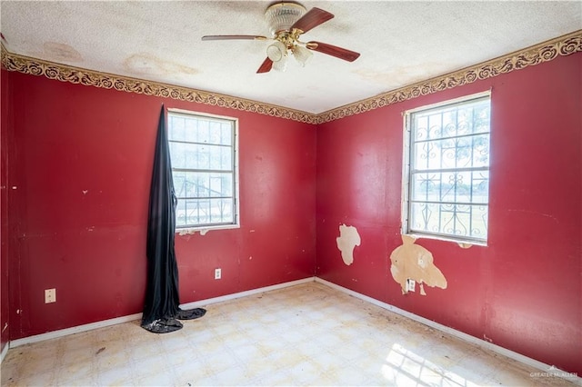 empty room with ceiling fan and a textured ceiling