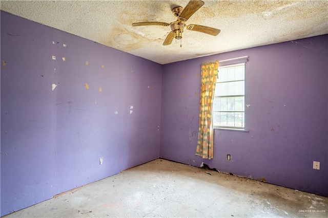 empty room with ceiling fan, concrete flooring, and a textured ceiling