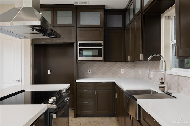 3716 Yellowhammer Ave, Mcallen, TX 78504 - kitchen featuring wall chimney exhaust hood, black range with electric stovetop, a sink, decorative backsplash, and dark brown cabinets