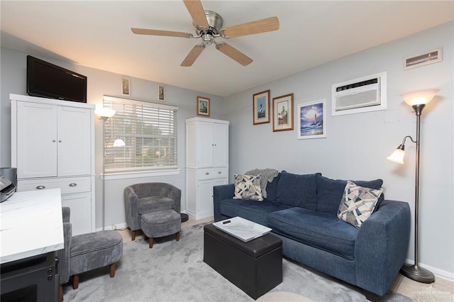 living area with a ceiling fan, baseboards, a wall unit AC, and light carpet
