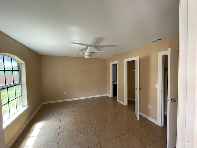 tiled empty room with ceiling fan