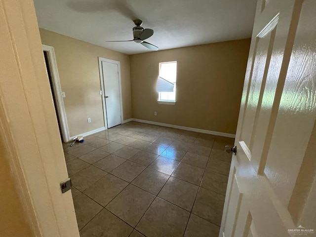 tiled empty room with ceiling fan