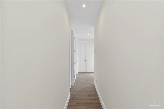 corridor with dark hardwood / wood-style flooring