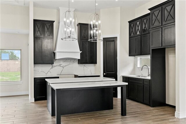 kitchen featuring a center island, sink, a kitchen breakfast bar, light hardwood / wood-style flooring, and decorative light fixtures